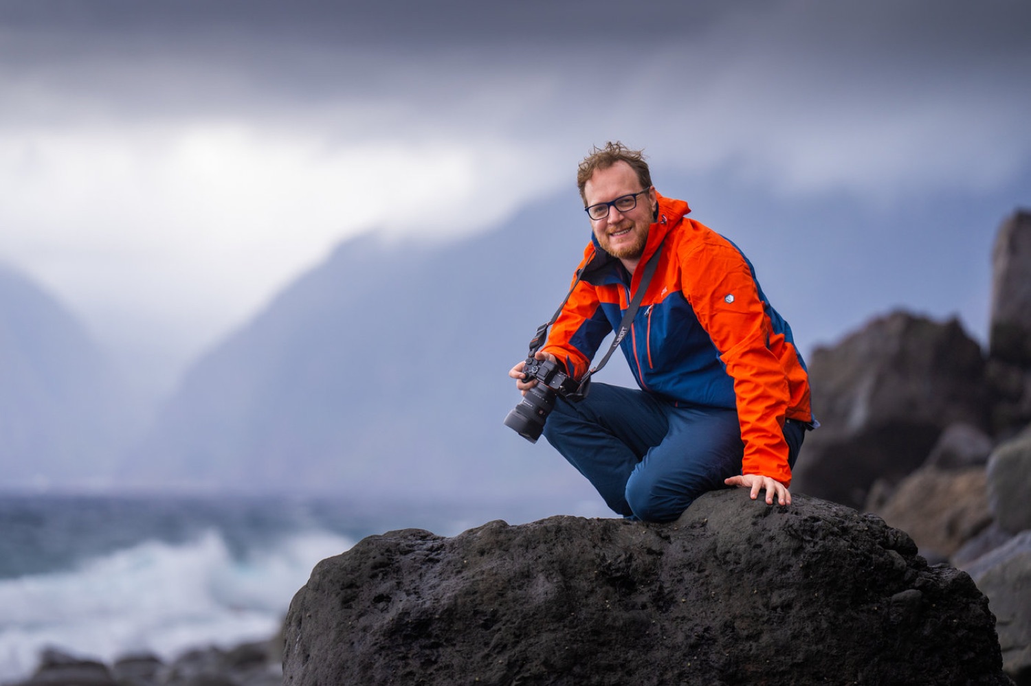 Albert Dros with his camera on a rock by a waterfall